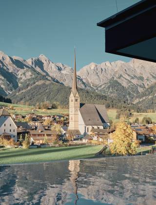 Goldener Herbst mit Ausblick auf die Berge vom Infinity Pool aus