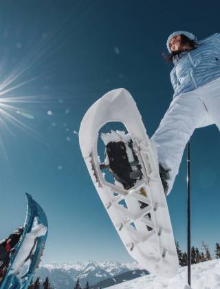 Paar beim Schneeschuhwandern in der verschneiten Winterlandschaft in den Bergen im Salzburger Land