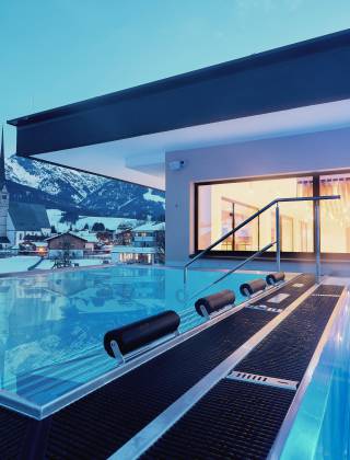 Infinitypool und Whirlpool mit fantastischer Aussicht auf die umliegenden Berge im Hotel die HOCHKÖNIGIN bei Abendstimmung