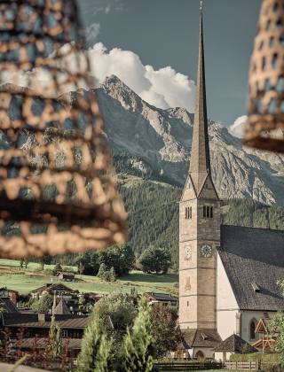 Blick von der Terrasse der HOCHKÖNIGIN auf die Kirche von Maria Alm und die umliegende Bergwelt