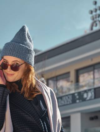 Frau im Winter mit Blick auf das Hotel die HOCHKÖNIGIN in Maria Alm