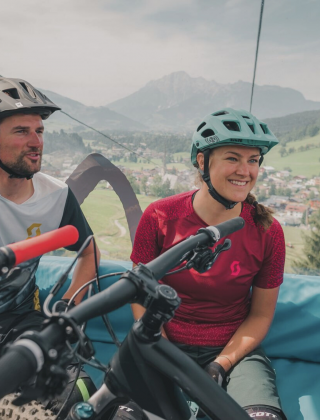 Paar in der Bergbahngondel mit dem Bike