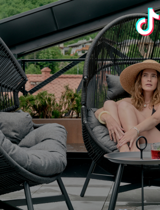 Woman relaxing in a cosy large armchair on the sun terrace