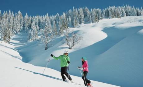 Paar beim Schneeschuhwandern in der verschneiten Winterlandschaft in den Bergen im Salzburger Land