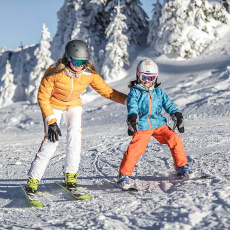 Frau lernt Kind Ski fahren