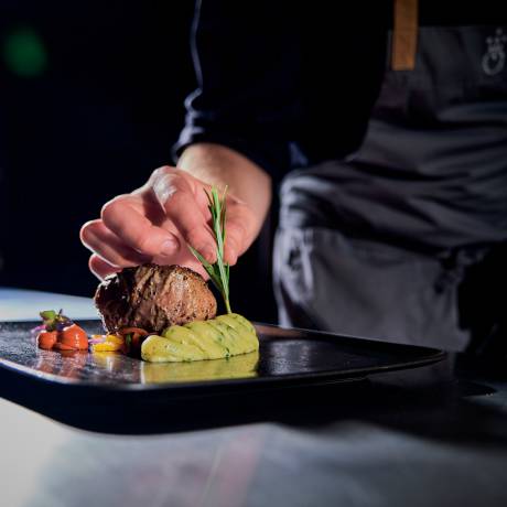 Fleisch mit Kartoffelpüree auf schwarzem Teller