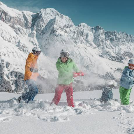 Familie im Schnee in den Bergen beim Skifahren