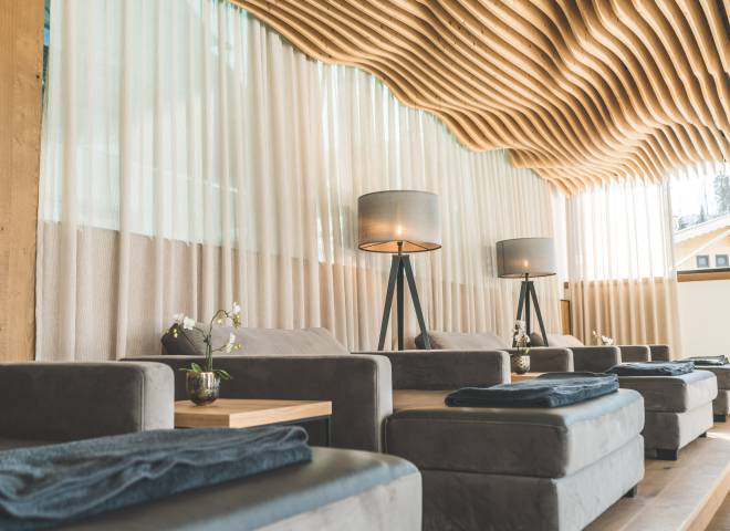 Relax area in the SPA with wavy wooden ceiling and comfortable upholstered loungers in modern design Wellnesshotel die Hochkönigin
