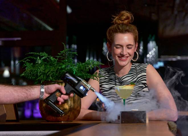 Frau an Hotelbar erhält ein Getränk
