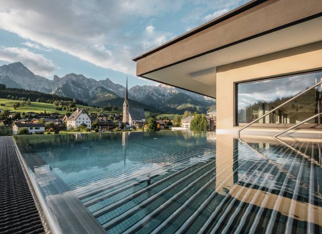 Outdoor pool the HOCHKÖNIGIN during the day in Maria Alm Wellnesshotel Luxury Hotel Family Hotel