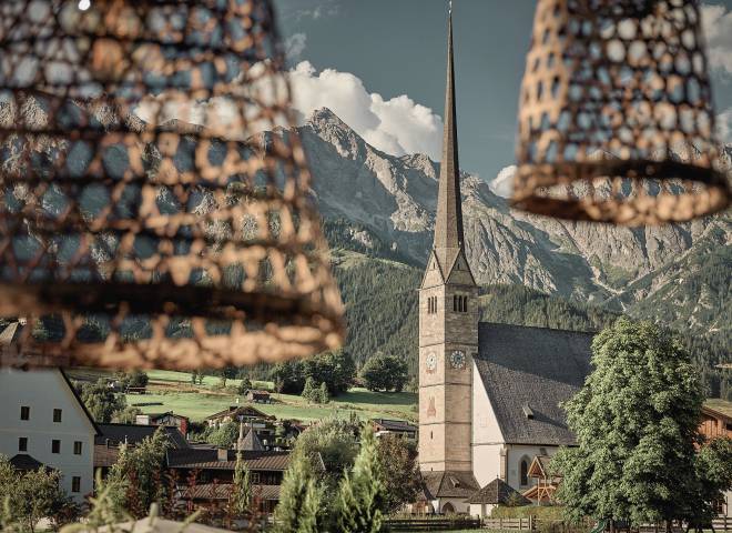View from the terrace of the HOCHKÖNIGIN to the church of Maria Alm and the surrounding mountains