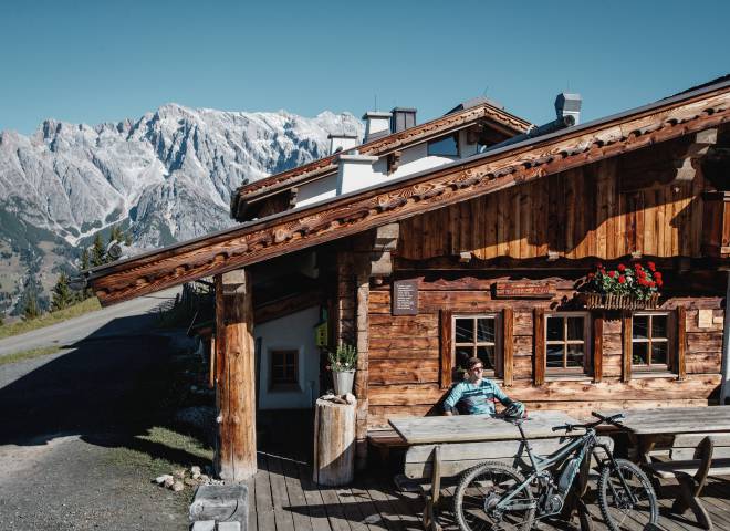 Biker beim ausruhen vor einer Almhütte in den Bergen der Region Hochkönig