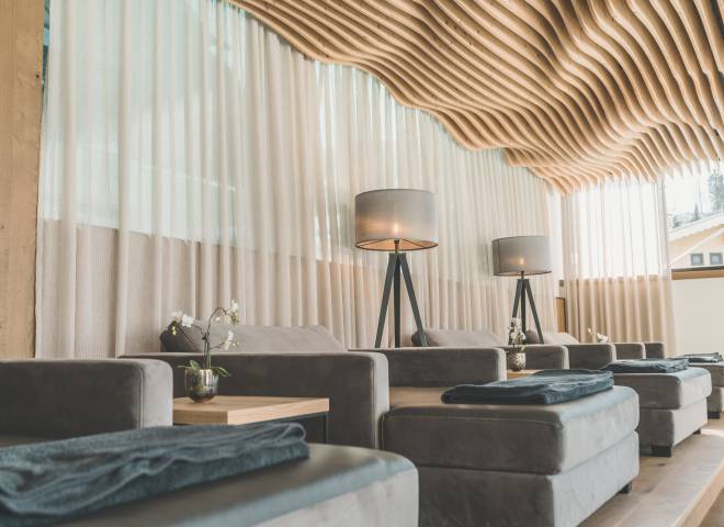 Relaxation area in the HotelSPA with cosy loungers and unusual curved wooden ceiling