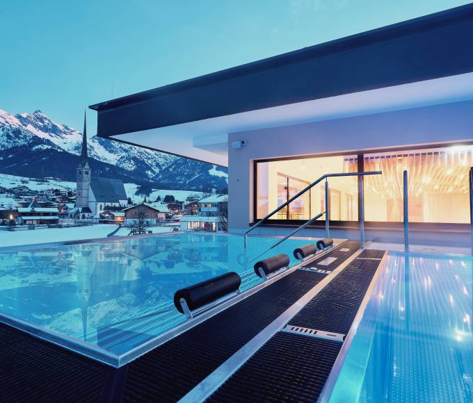 Infinity pool and whirlpool with a fantastic view of the surrounding mountains at Hotel die HOCHKÖNIGIN in the evening atmosphere