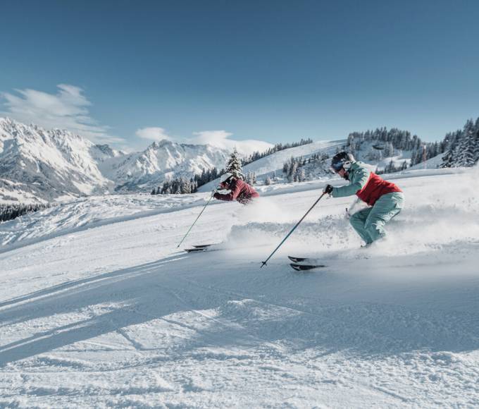 Skiers in beautiful sunshine and dream snow conditions in the Hochkönig region