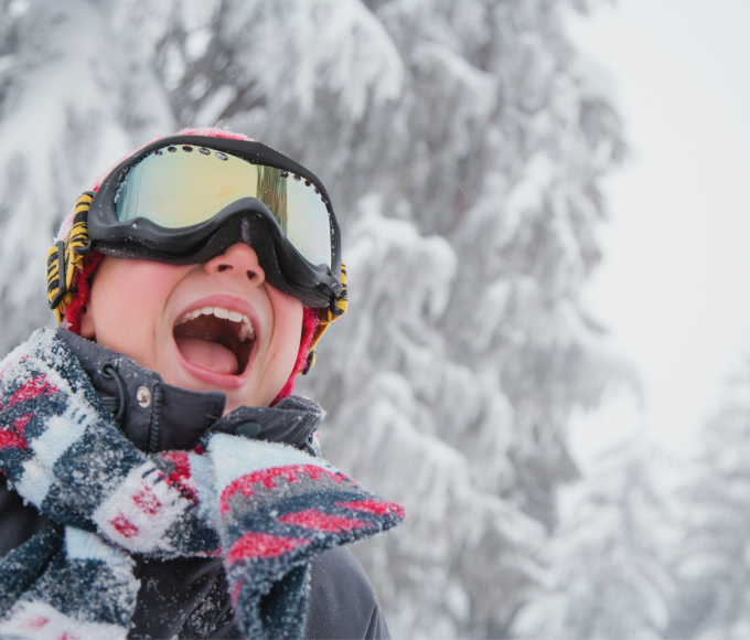 Kind mit Skibrille im Schneetreiben in den Bergen