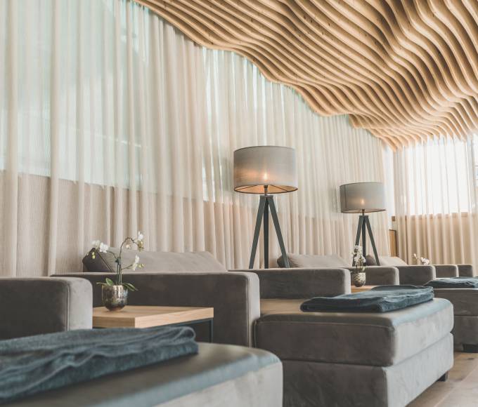 Relaxation area in the HotelSPA with cosy loungers and unusual curved wooden ceiling