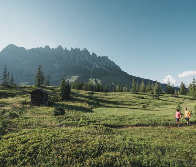 Couple hiking on a high plateau in summer with a view of the mountains