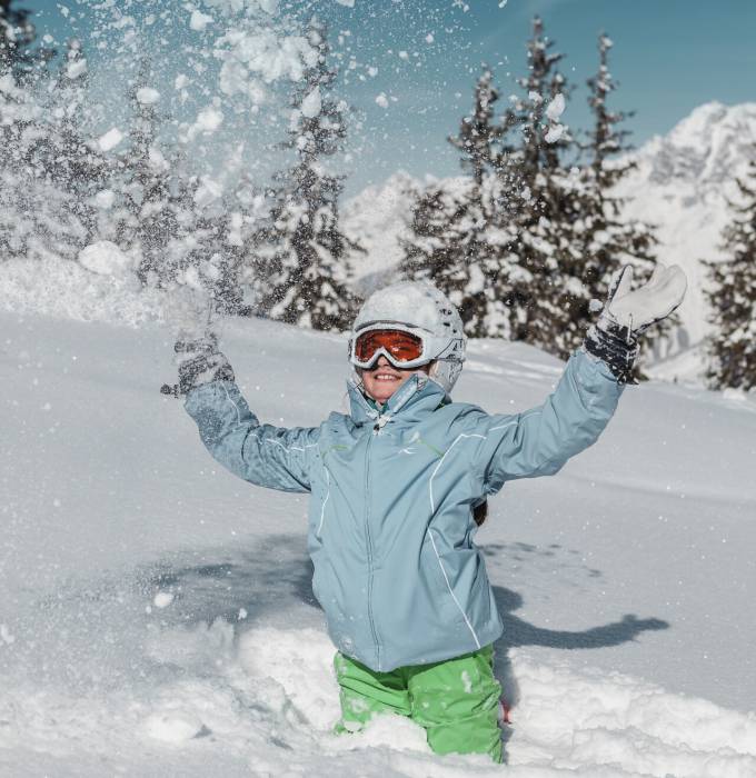 Child in the mountains with beautiful snow and sunshine