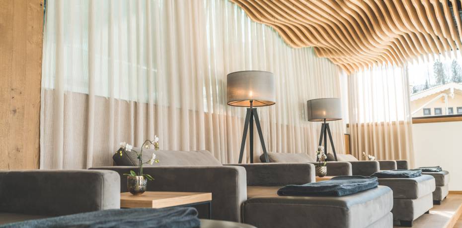 Relax area in the SPA with wavy wooden ceiling and comfortable upholstered loungers in modern design Wellnesshotel die Hochkönigin