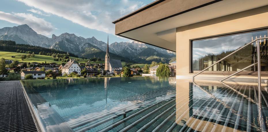 Outdoor pool the HOCHKÖNIGIN during the day in Maria Alm Wellnesshotel Luxury Hotel Family Hotel