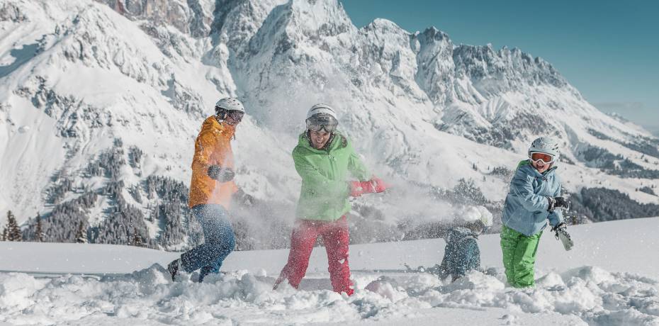 Familie im Schnee in den Bergen beim Skifahren