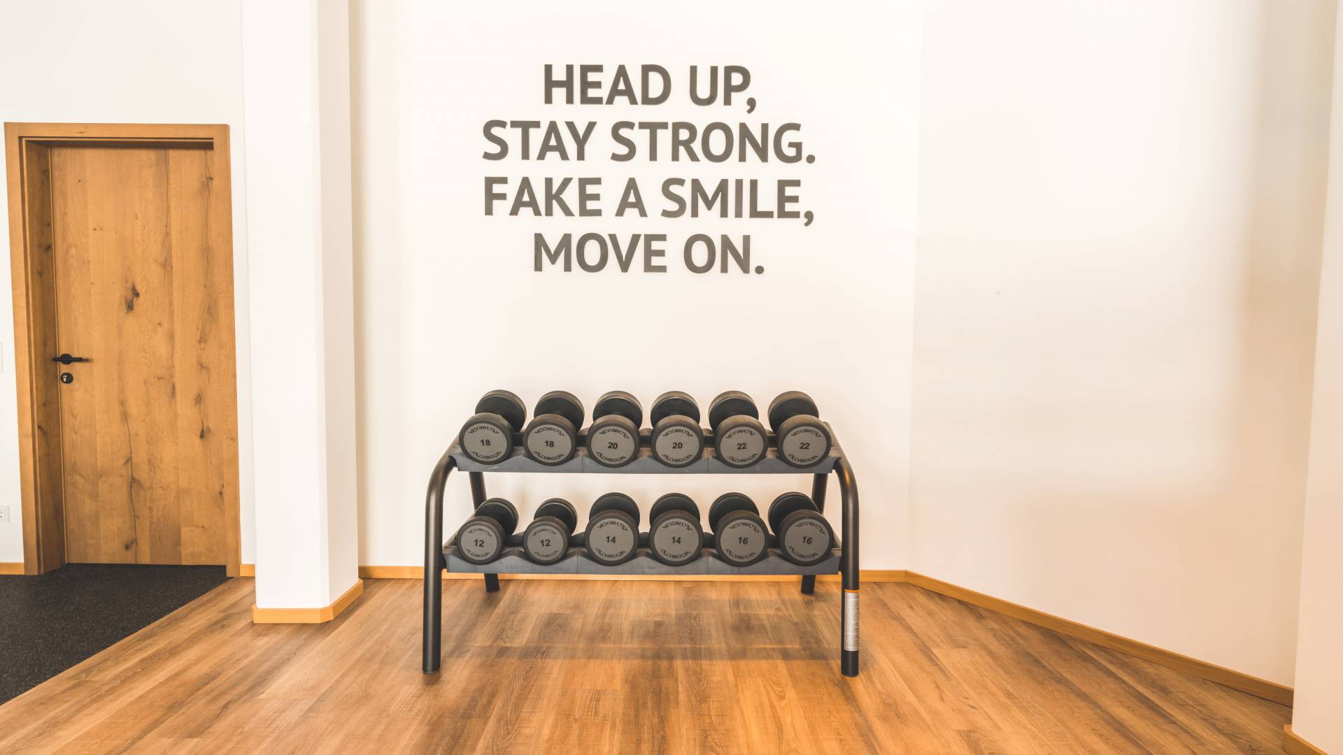 Fitnessbereich Hanteln mit Motivationsspruch