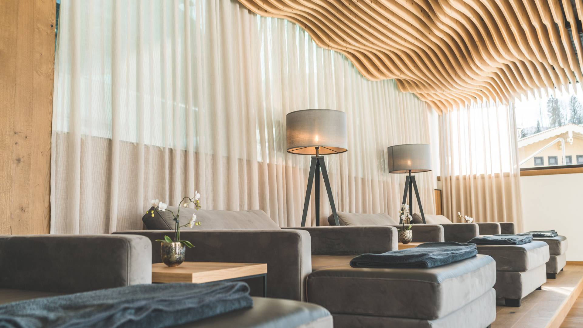 Relax Bereich im SPA mit gewellter Holzdecke und bequemen Polsterliegen in modernen Design Wellnesshotel die Hochkönigin