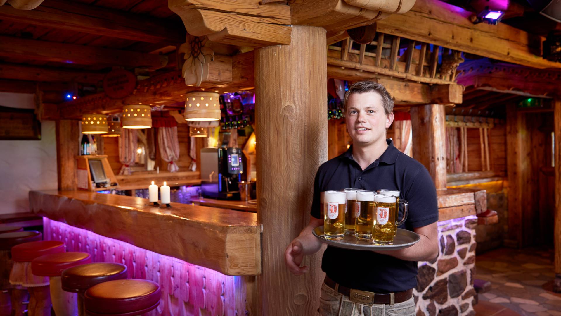 Kellner in Degl Alm serviert Bierkrüge