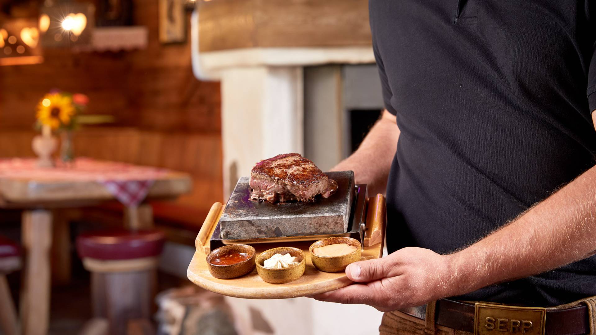 Kellner zeigt Steak mit Saucenvariation