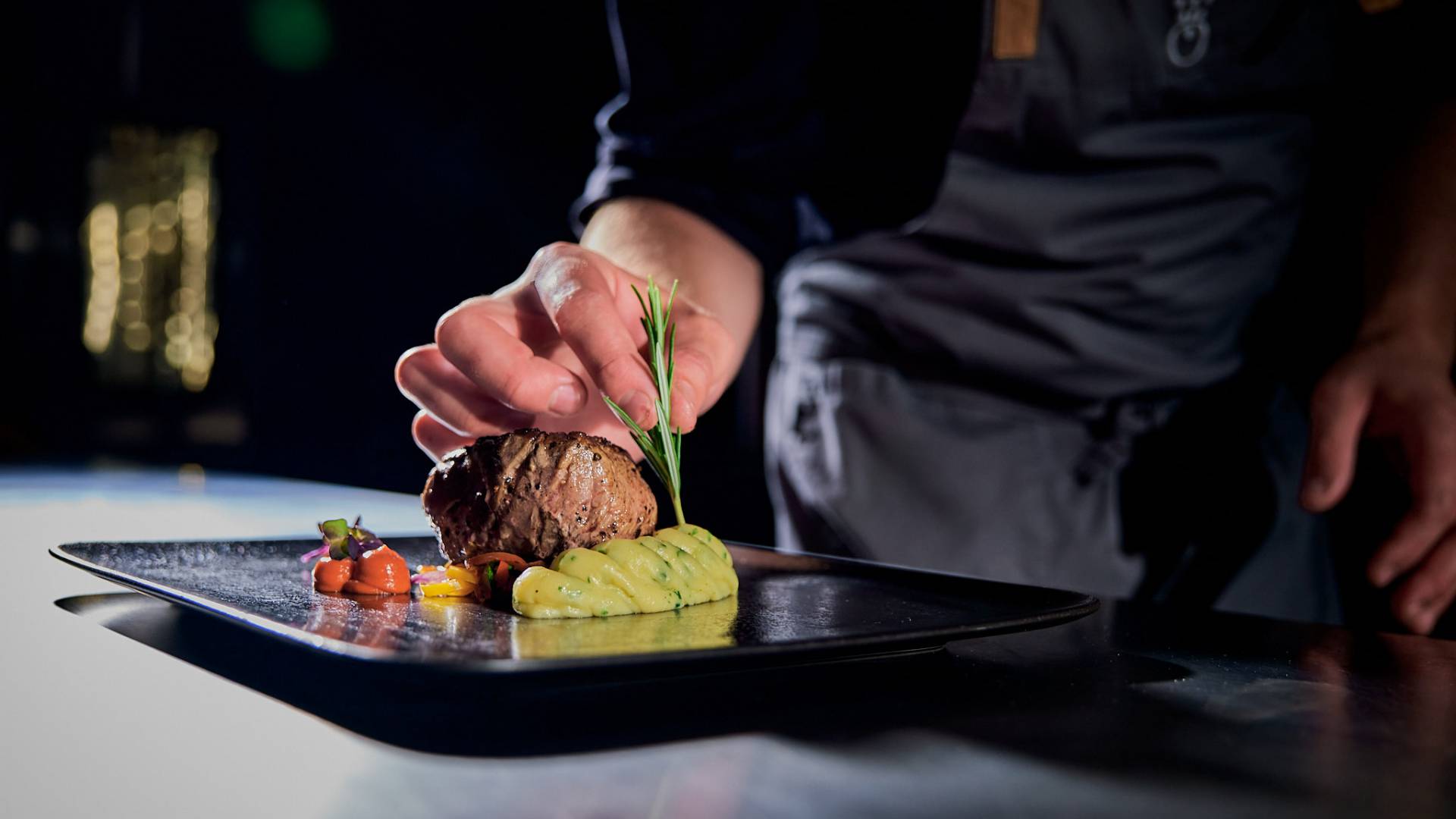 Fleisch mit Kartoffelpüree auf schwarzem Teller