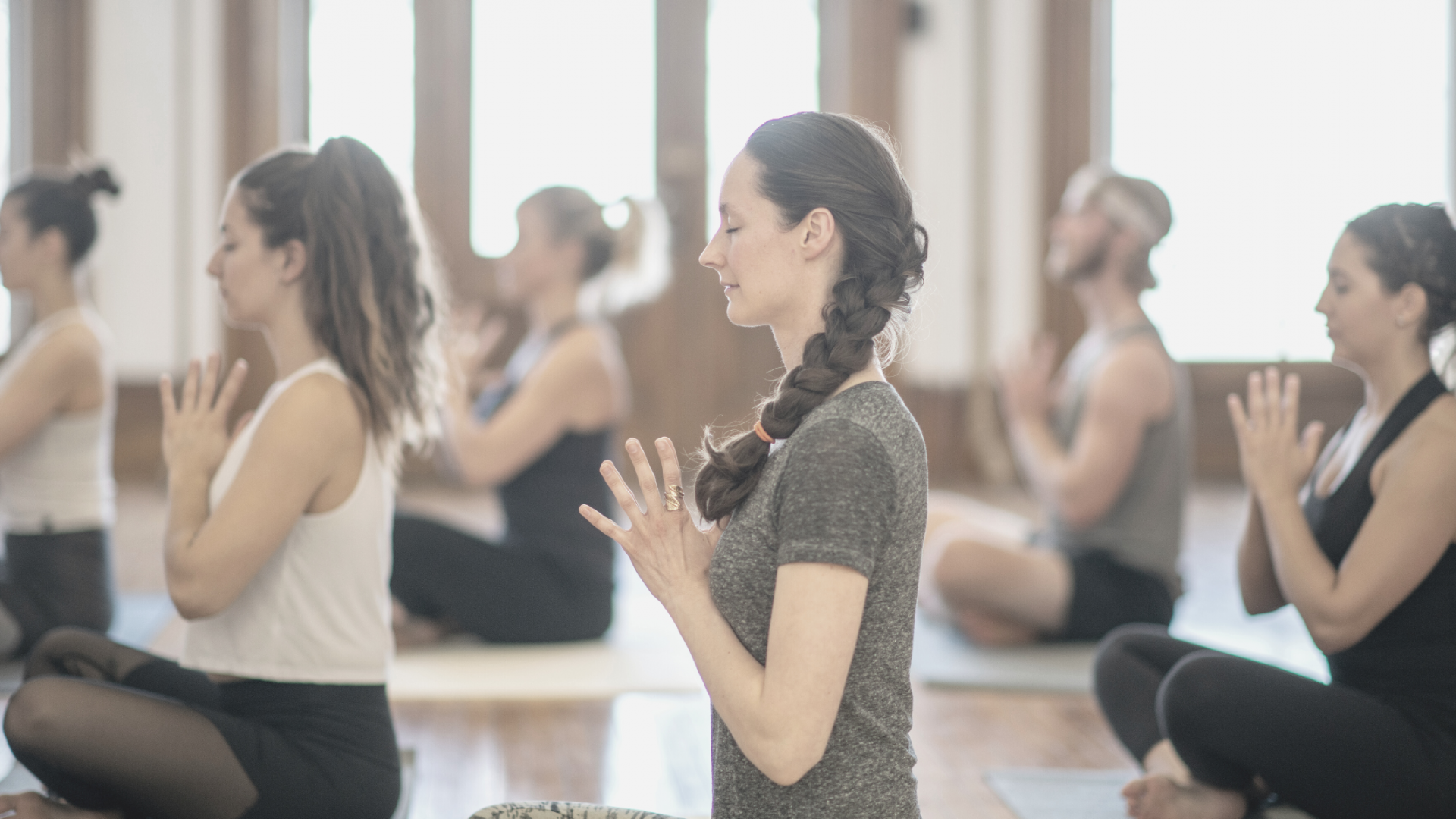 Fitnessraum mit Yogamatten und Yogadamen in hellen Farben