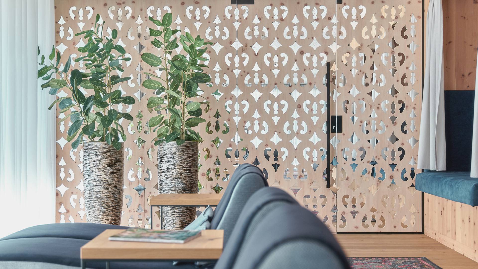 Relaxation area with cosy bunks and upholstered loungers in a room with ornaments in a stone pine wall