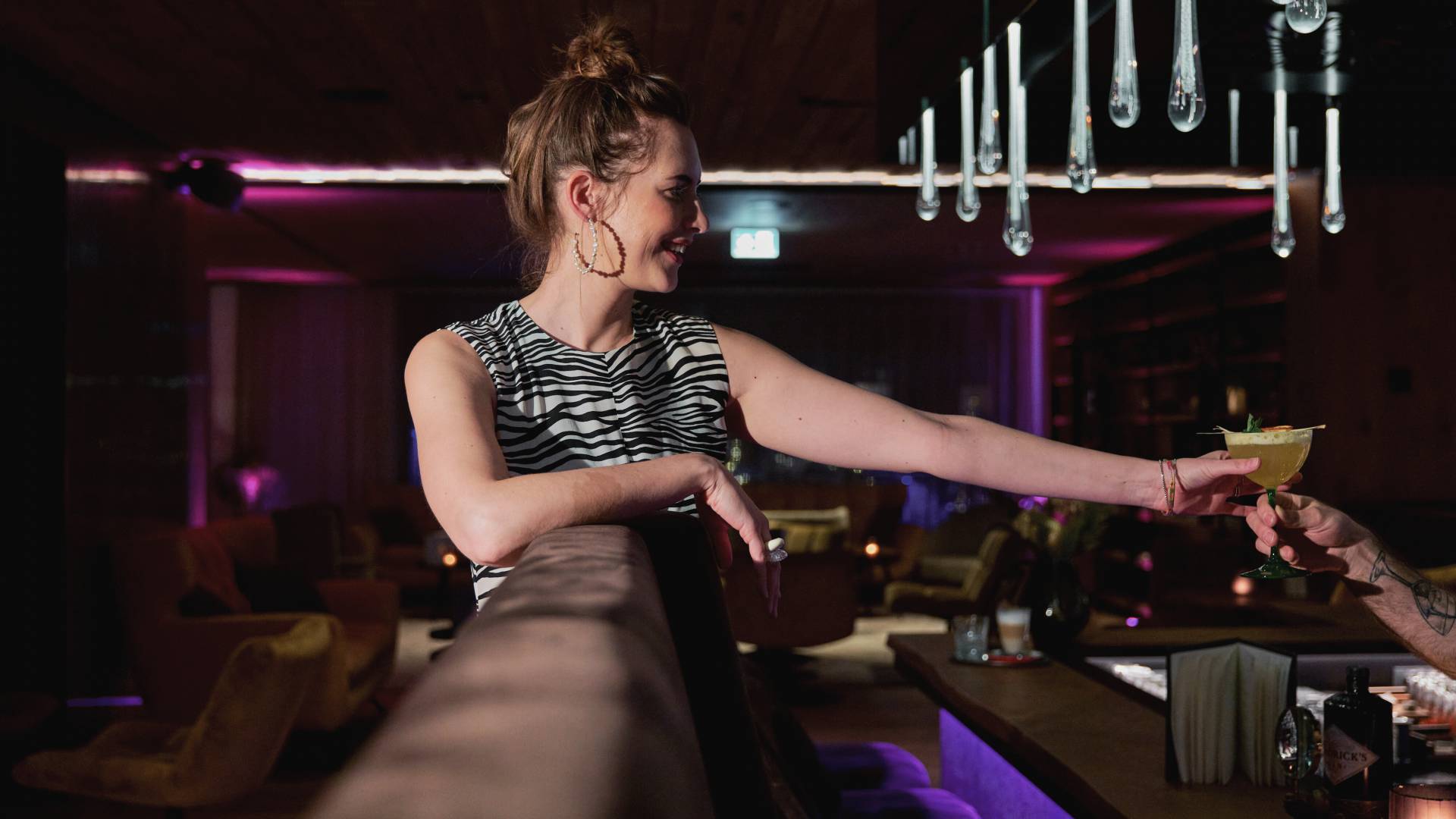 Frau an der HIGH QUEEN BAR der HOCHKÖNIGIN mit einem Cocktail