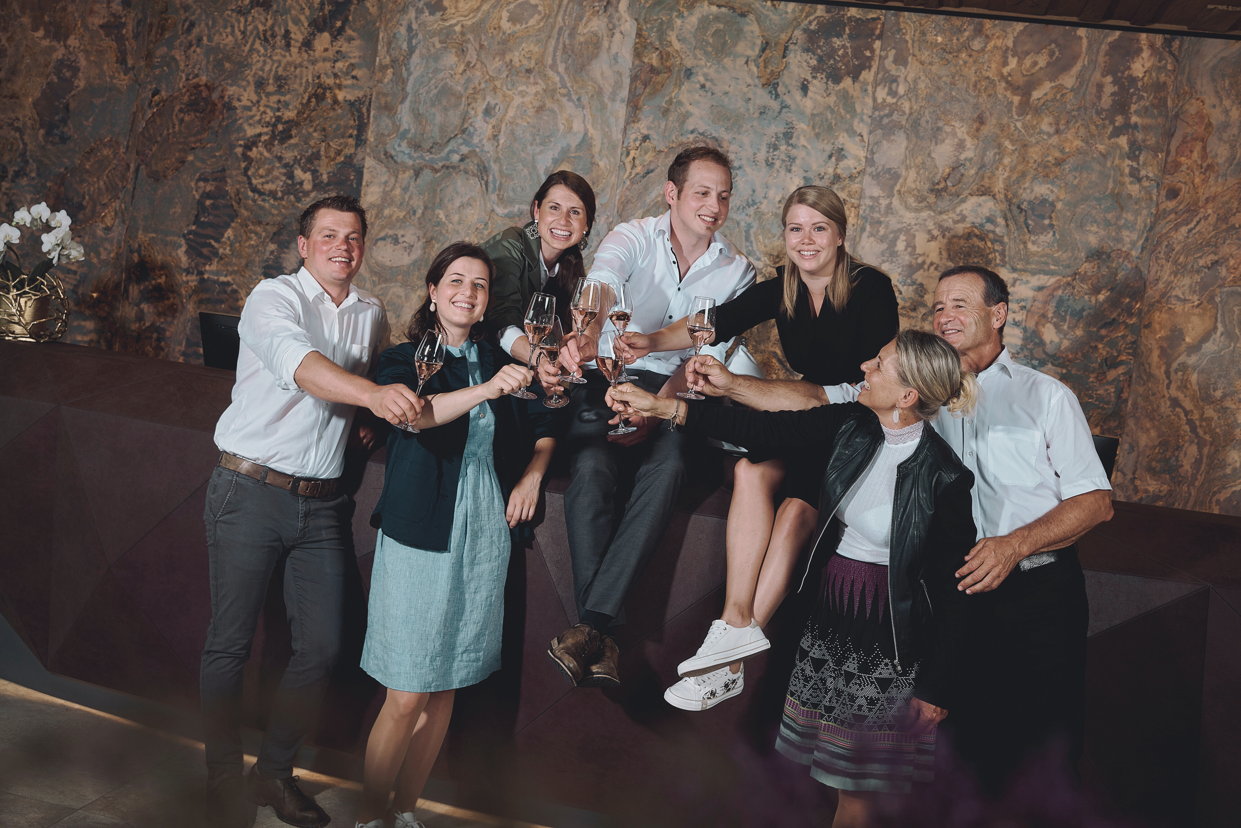 The Hörl family toasting with a glass of champagne in the stylish atrium of Hotel die HOCHKÖNIGIN